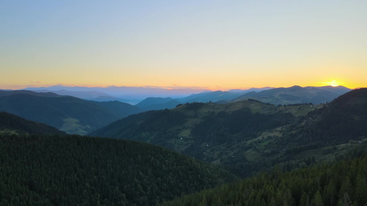 美丽的自然景观。鸟瞰山野中五彩缤纷的日落。黑暗的松林被明亮的夕阳照亮视频素材