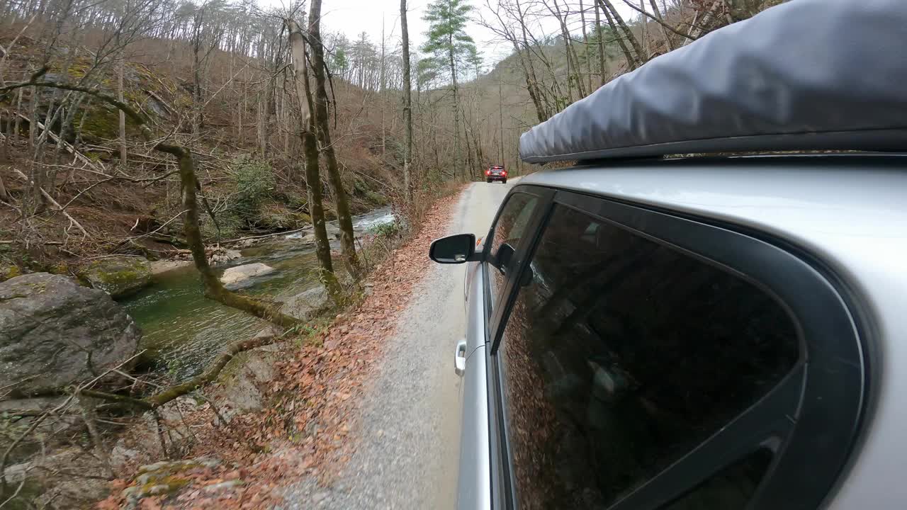 两辆陆路车辆行驶在蜿蜒的山间小路上视频素材