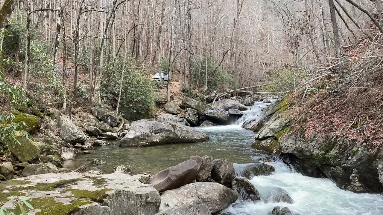 高架公路上的SUV，旁边是山间瀑布视频素材