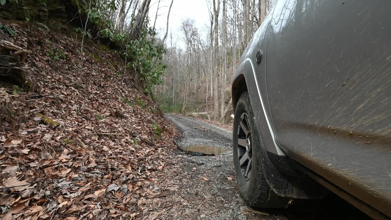 越野车辆行驶在砾石乡村道路在山区通过泥坑视频下载