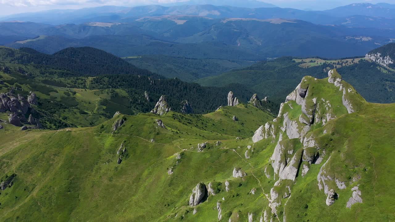 在充满活力的绿色岩石山脉和悬崖上飞行，鸟瞰图视频素材