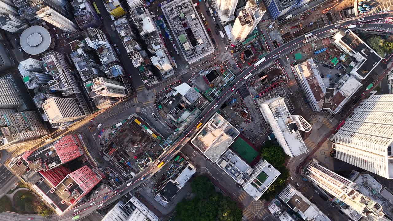 以绿色可持续智慧城市为主题，有道路日出的香港住宅区和有太阳能电池板的巴士。无人机视频旋转拍摄加速运动。视频素材