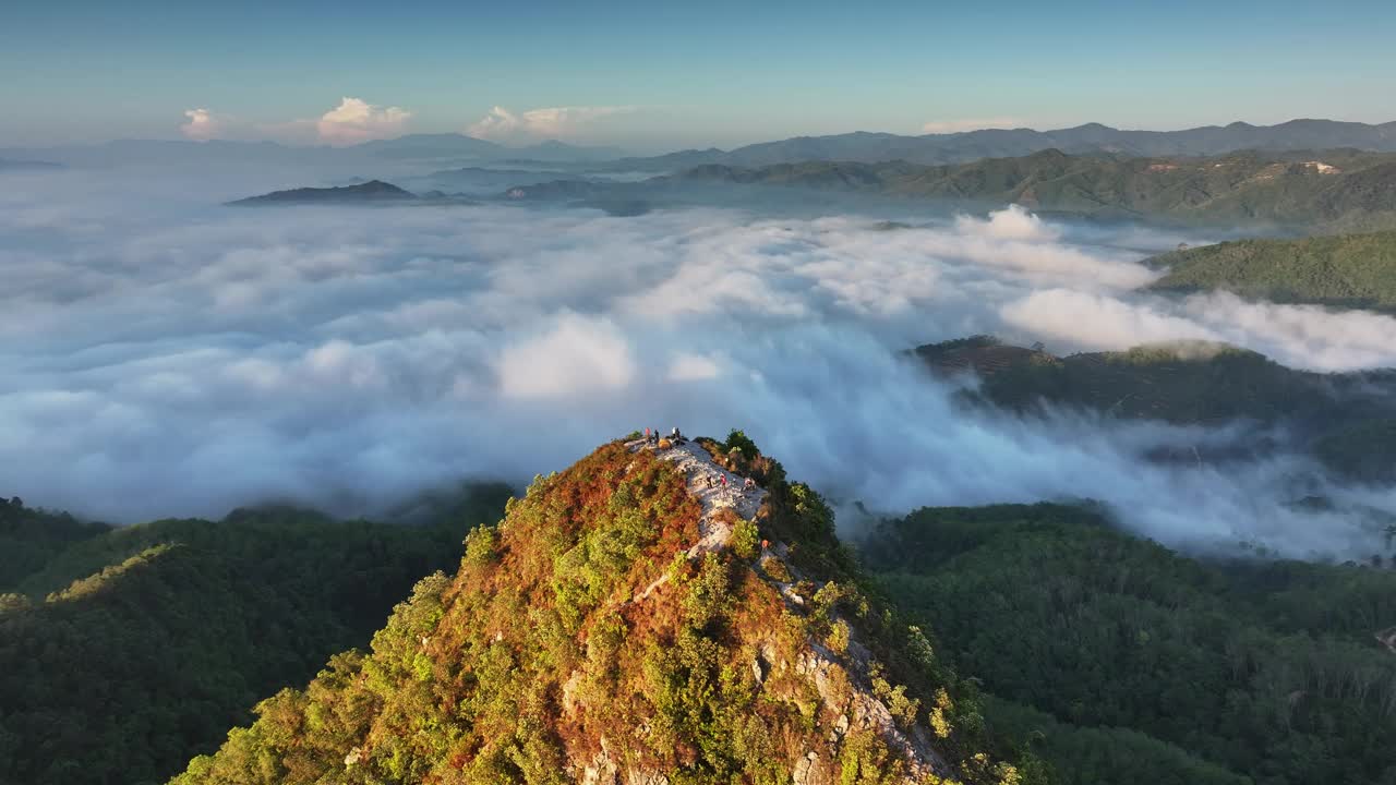 空中苍蝇绕着山峰飞行，在雾海中露出日出视频下载