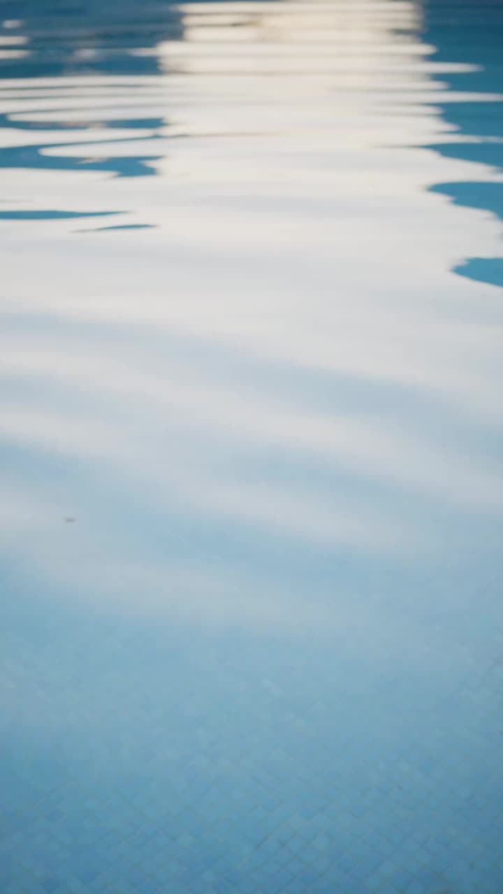 泳池水的垂直慢动作视频与阳光反射在整个框架中移动视频下载