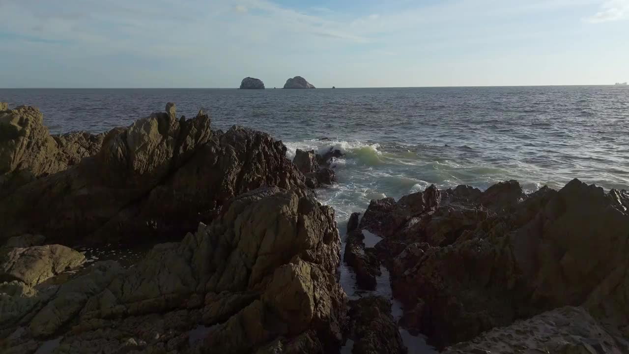 无情的大海猛烈地撞击着一群崎岖的岩石视频素材