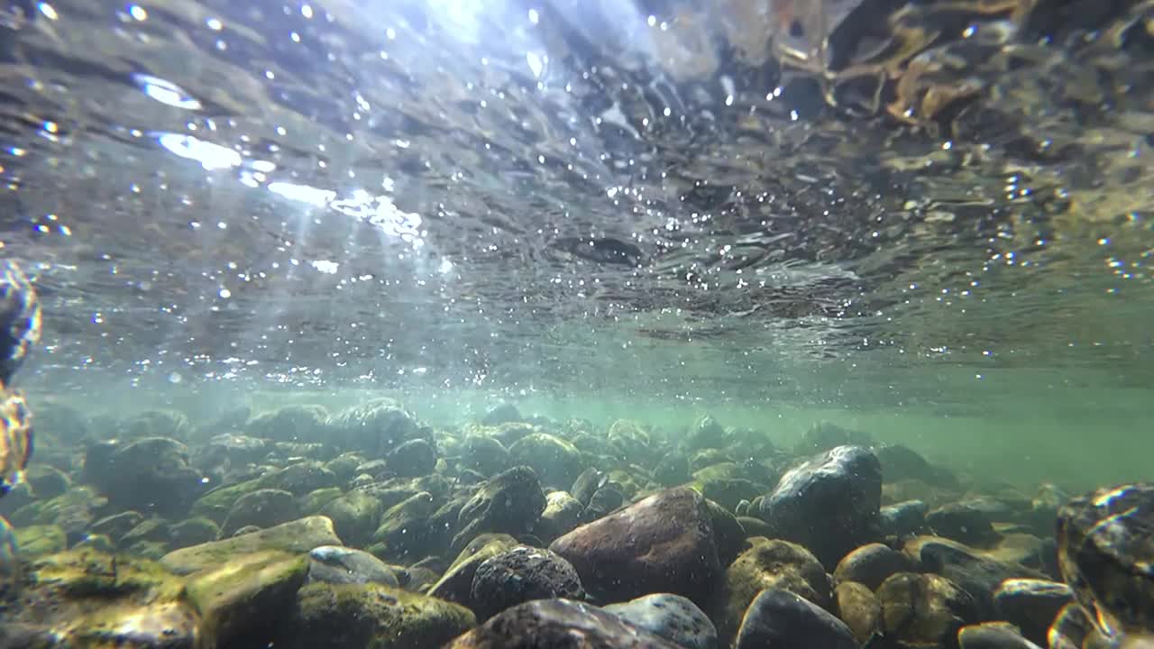 水下视频与石头和阳光在流动的水在慢动作视频素材