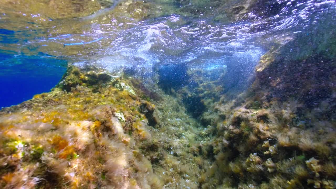 岩石海岸附近海浪的水下景观。视频素材