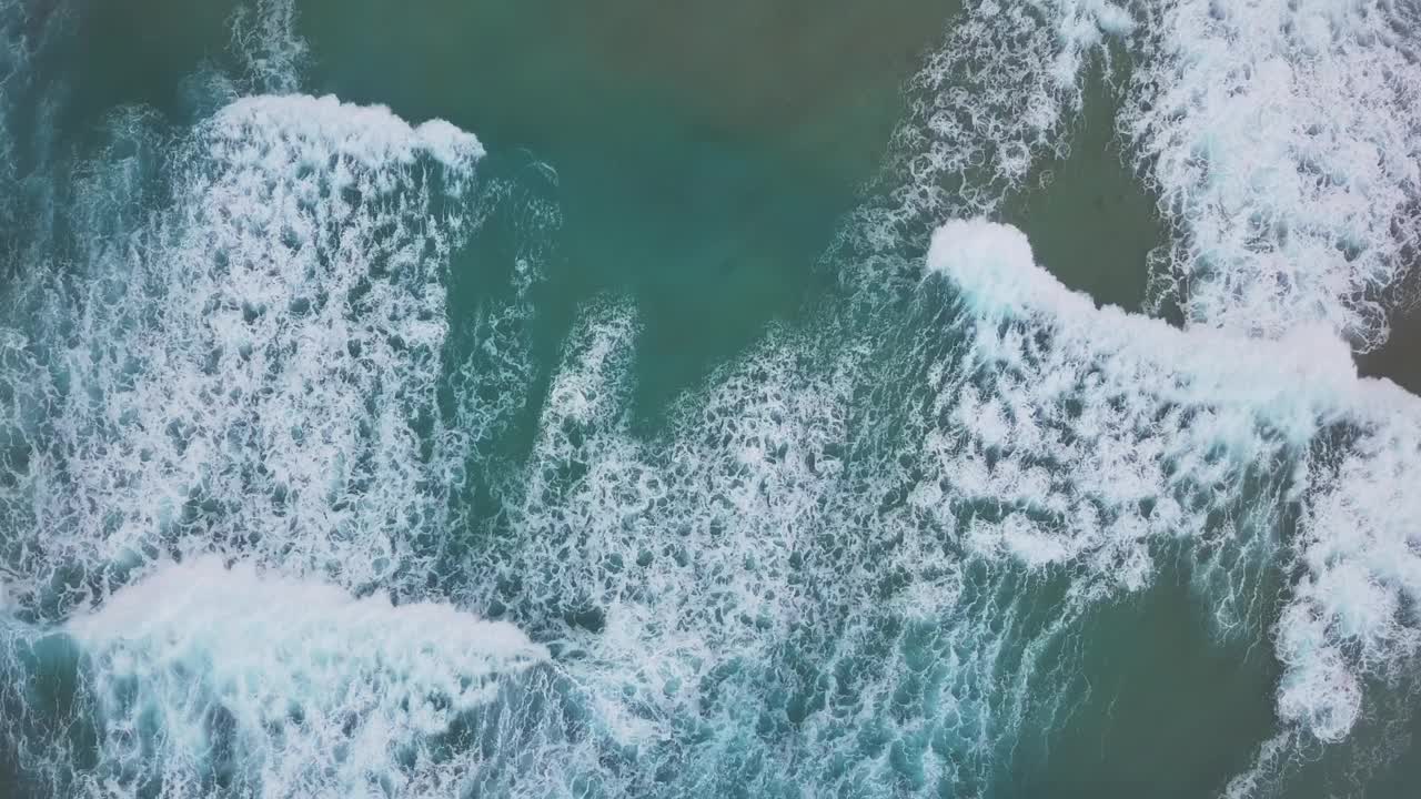 海浪拍打沙漠沙滩的鸟瞰图视频素材