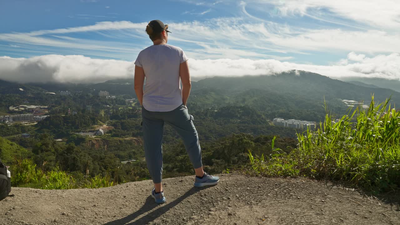 马来西亚金马伦高地，一名女徒步旅行者登上山顶，在悬崖边缘欣赏令人惊叹的日出视频下载