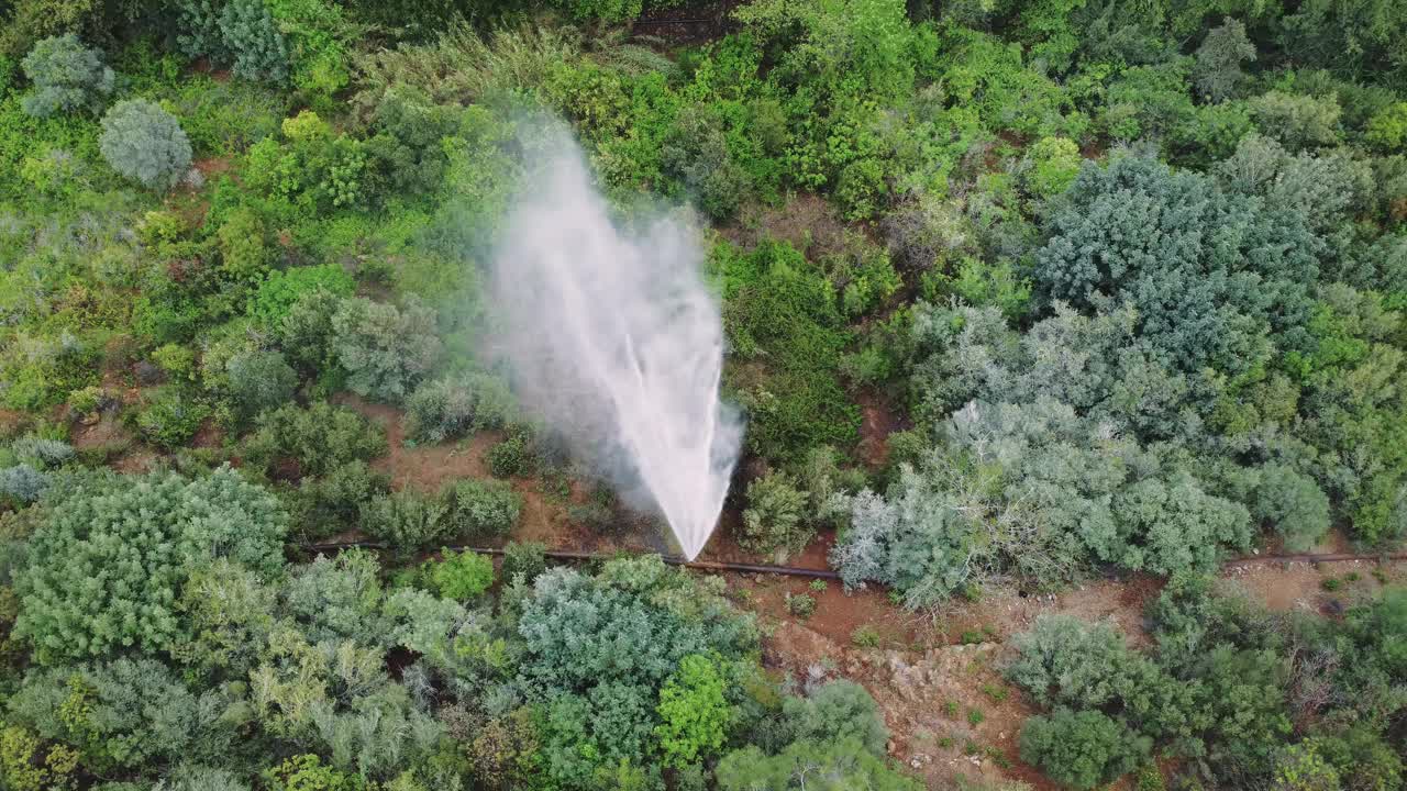 无人机拍摄到事故，管道在青山峡谷破裂。事故的航拍画面，水管喷水。紧急应对事故，自然管道损坏视频素材