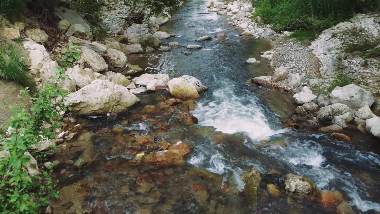 无人机看到美丽的山涧，在森林与清澈的水。从低空拍摄的美丽的山和溪流。环保注重美观，山川、溪流保育视频素材