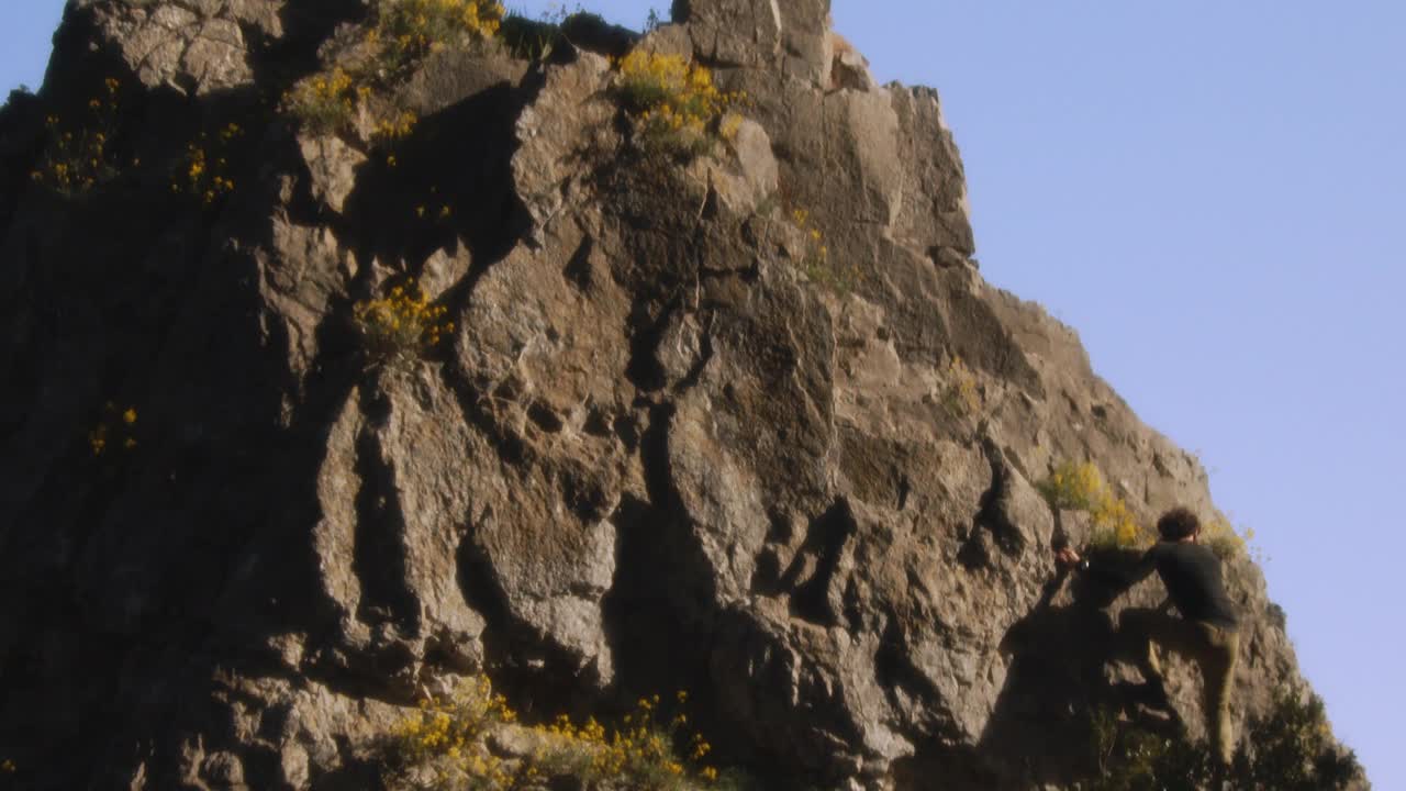 胜利的登山者到达顶峰:在明亮的日光下，岩石顶峰成就的惊人远景，户外运动成功的电影6K捕捉视频下载