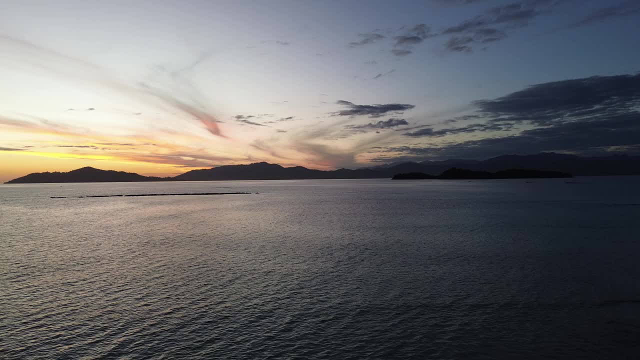 海上日出的鸟瞰图。飞过水面，看到美丽的日出视频素材