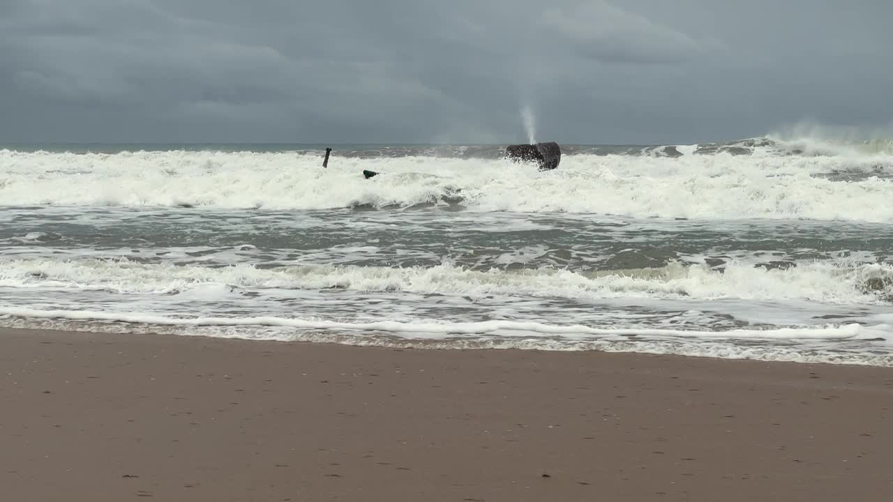 在西班牙的海岸线上，在多云和忧郁的天气背景下，海浪冲击着海岸，描绘了海洋与自然永恒的舞蹈。视频素材