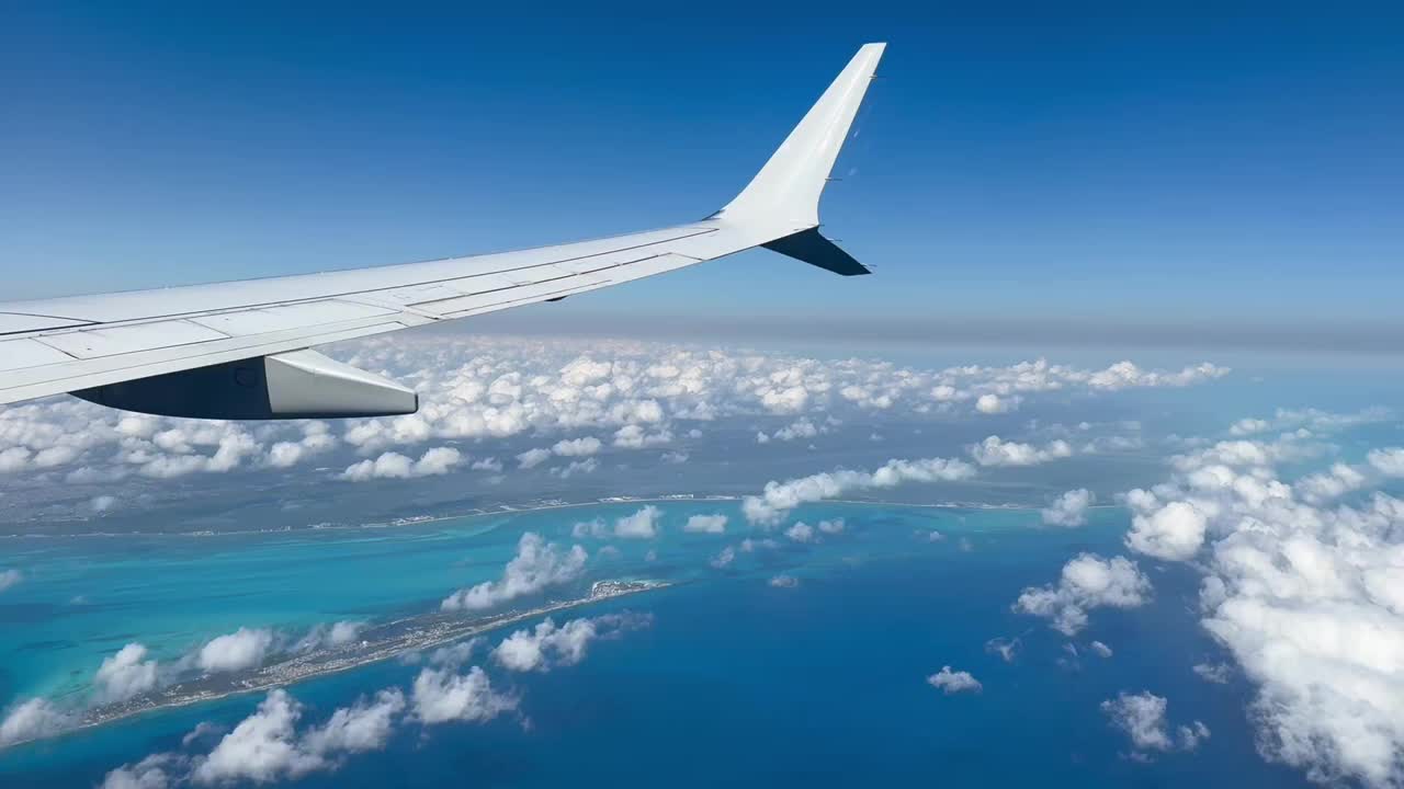 飞机机翼飞过墨西哥海岸线上空的云层，降落在坎昆视频下载