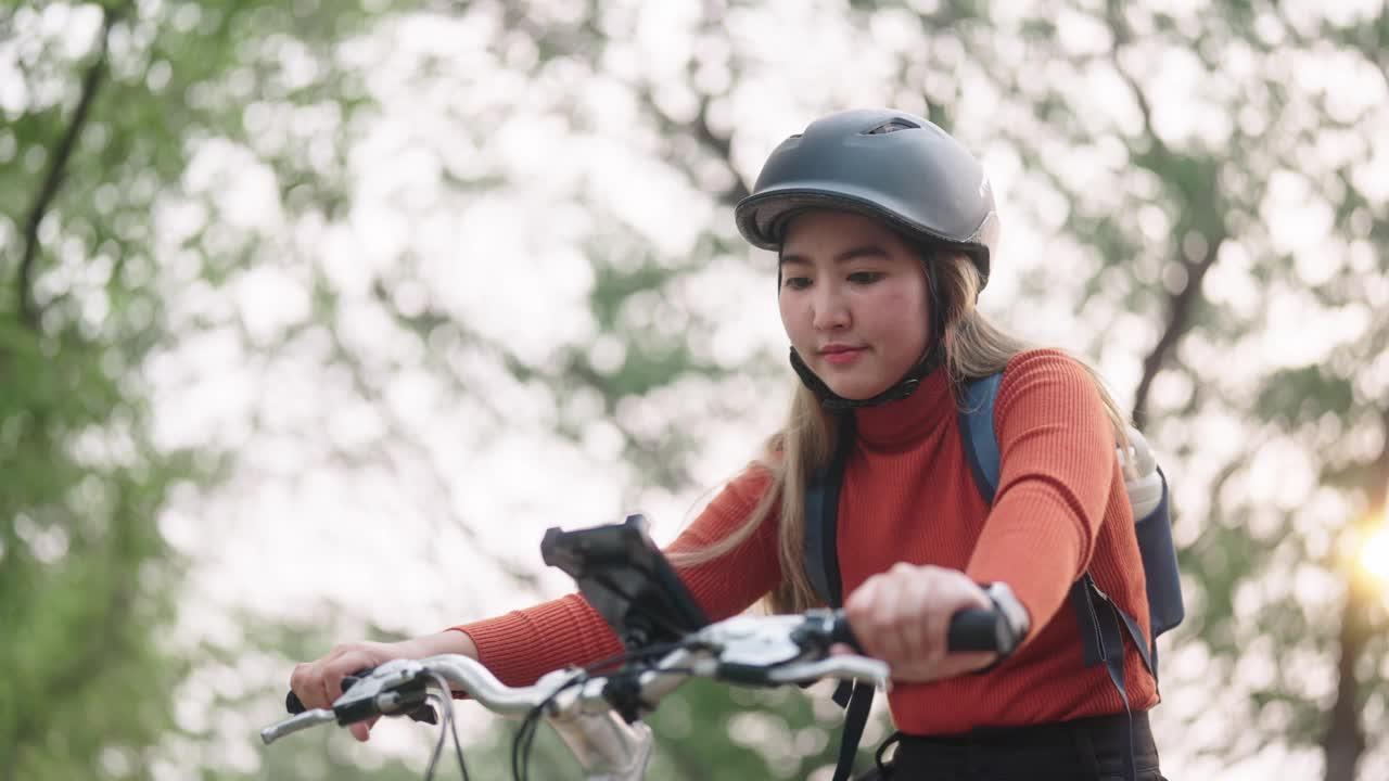 女子骑自行车旅行时使用智能手机。视频下载