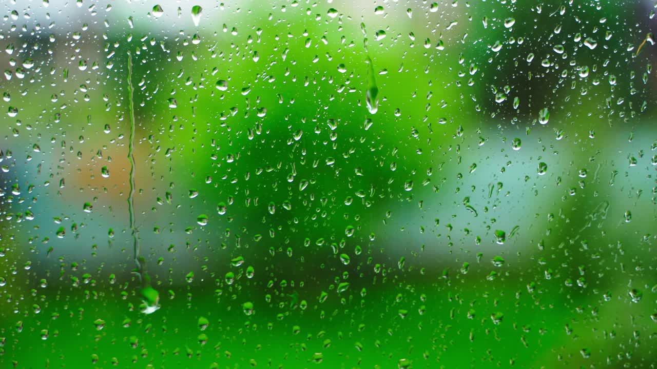 雨滴落在乡间别墅的窗户上，特写，背景模糊。雨的季节视频素材