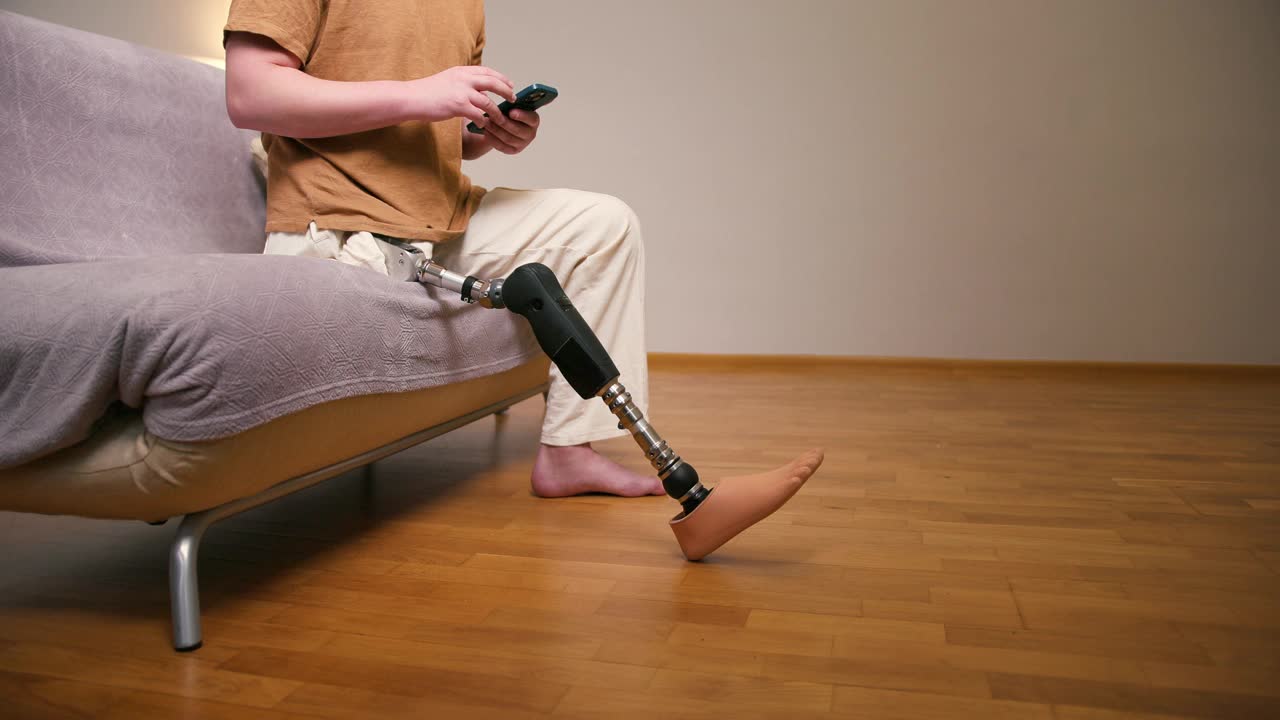 家用智能手机近距离拍摄一名截肢者膝关节以上经股腿假体人工装置。截肢残障人士的日常生活视频素材