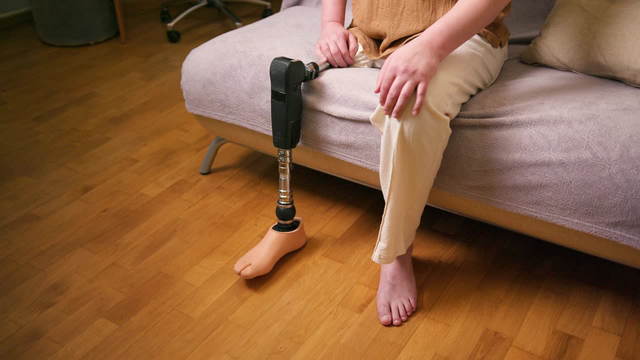 男截肢者膝以上经股腿假体人工装置在家中的近照。截肢残障人士的日常生活视频素材