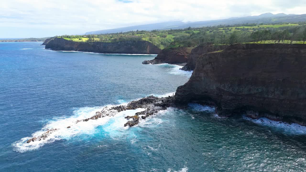 鸟瞰夏威夷的岩石海岸，蓝色的海洋和绿色植物。视频素材