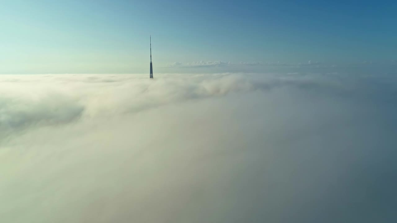 电视塔顶在云中，以蓝天为背景。视频素材