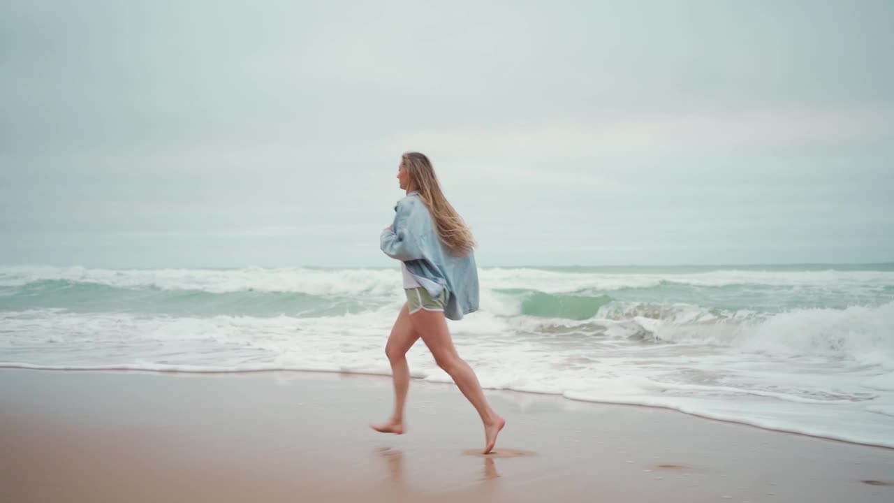 无忧无虑的年轻女子在海滩上享受海浪视频素材