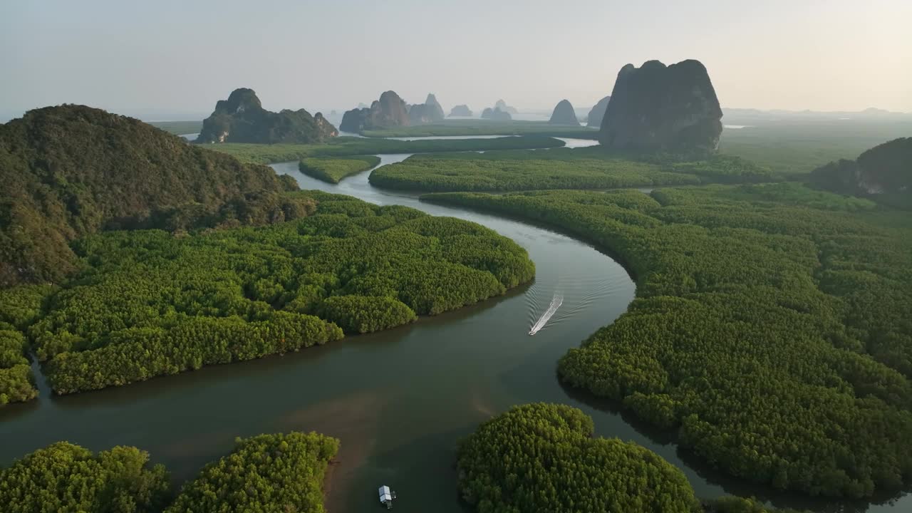 无人机跟踪一艘船在河上的红树林，泰国视频下载