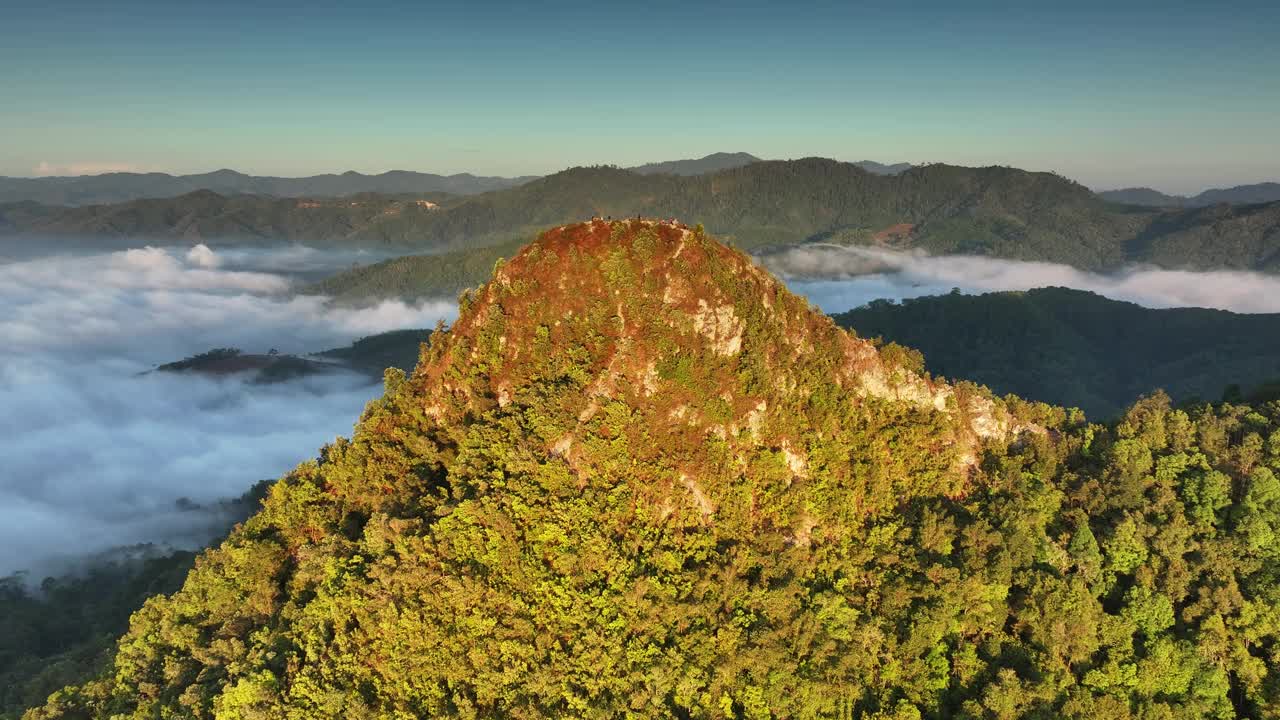 空中苍蝇绕着山峰飞行，在雾海中露出日出视频下载