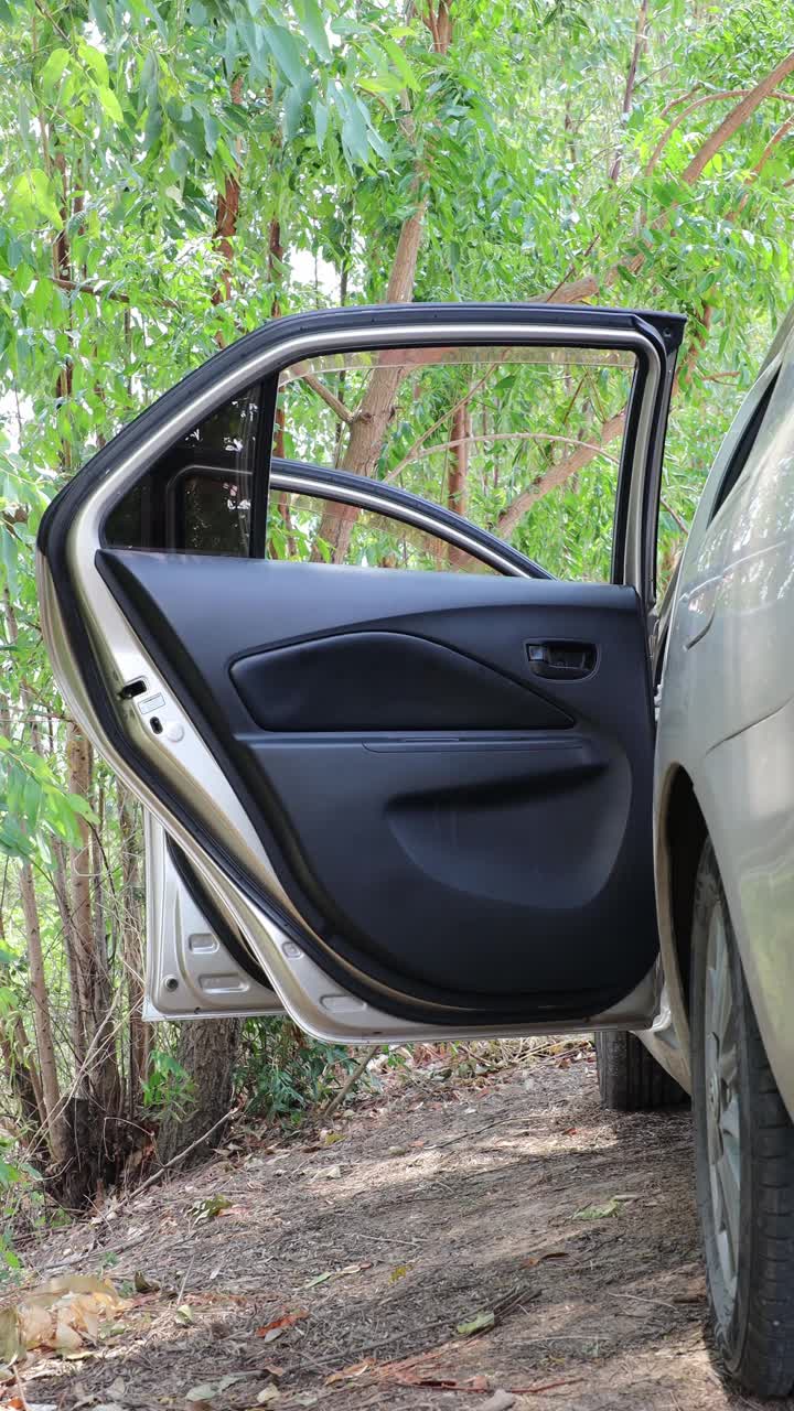 一个停着的车门被司机打开和关闭的垂直低角度特写。视频下载