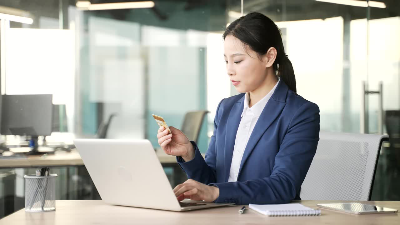 心烦意乱的年轻亚洲女商人在办公室检查笔记本电脑上的信用卡时发现了欺诈行为。视频素材