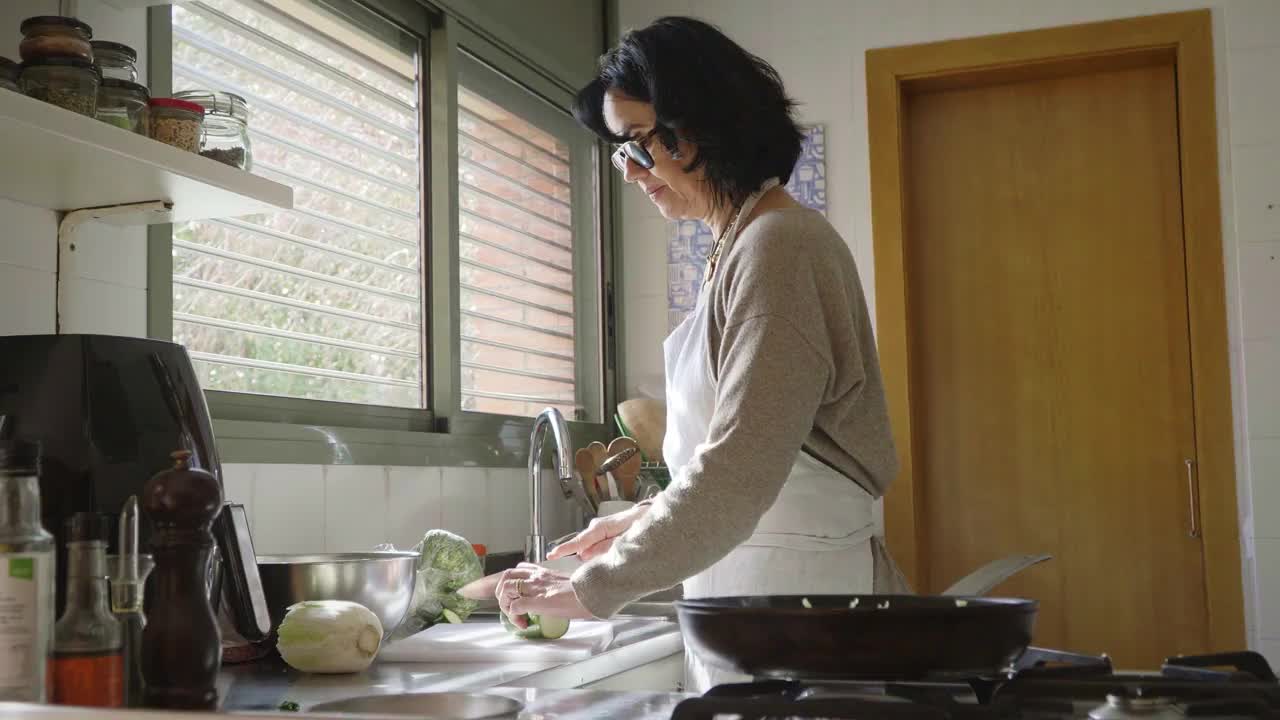 妇女在家庭厨房里准备健康的饭菜视频素材