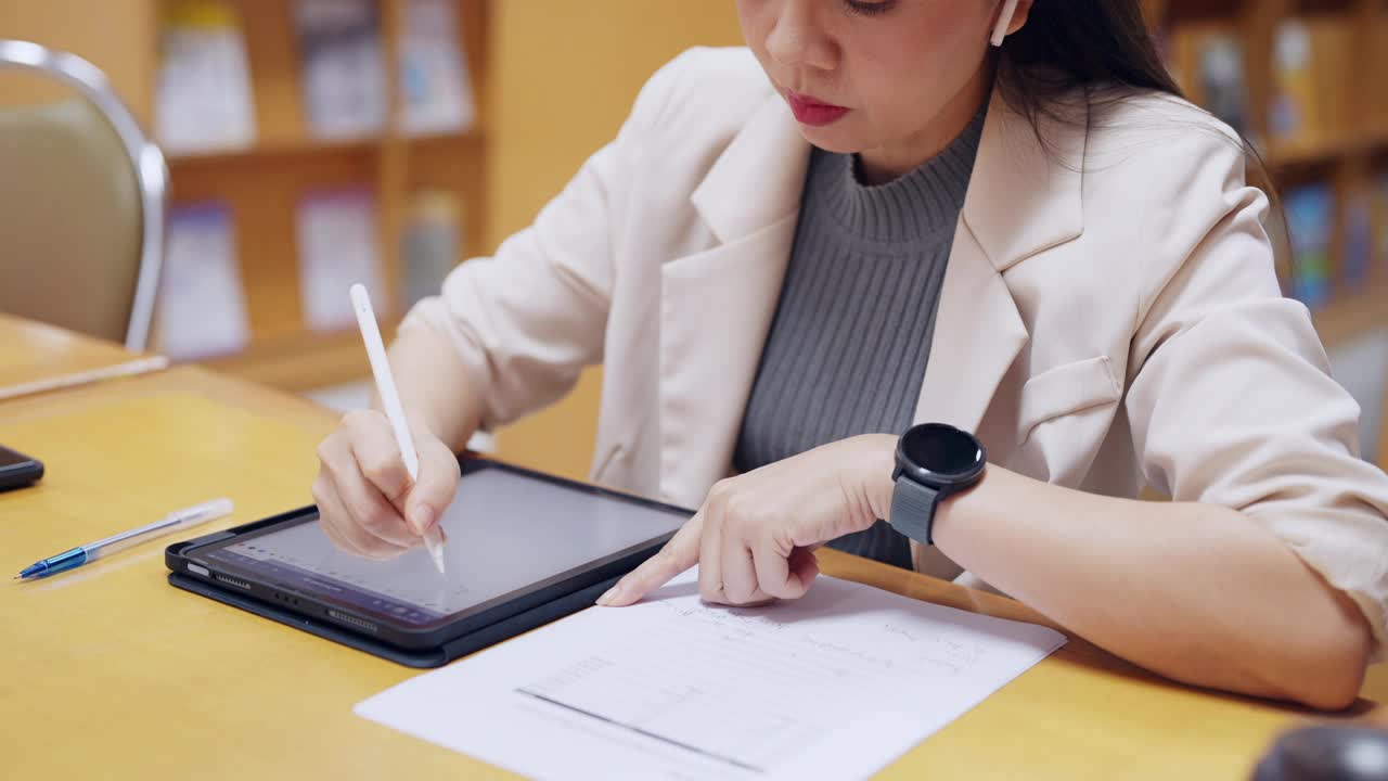 一个女人正在用一支笔在写字板上写字视频素材