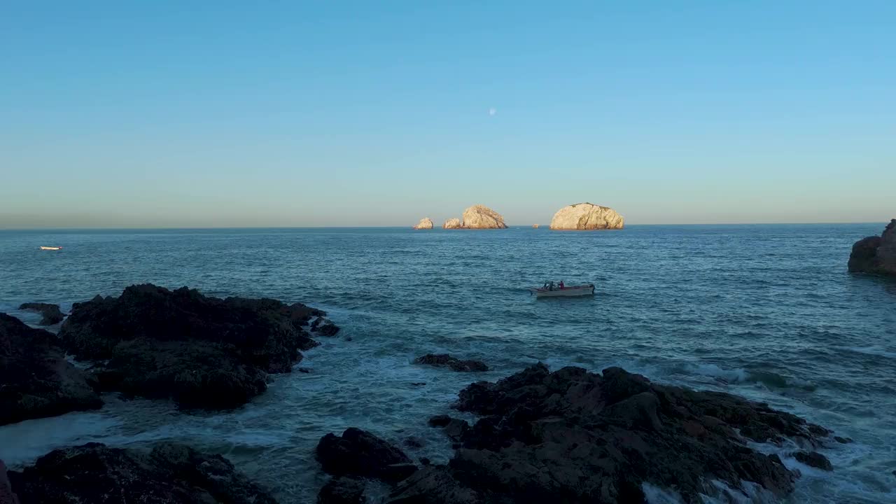 海岸奥德赛:从马萨特兰的岩石海岸线到迷人的白色岛屿的壮丽空中之旅。在优雅的鹈鹕的指引下，当日出照亮了金色的岩石时，见证渔民准备他们的公海航行。视频素材