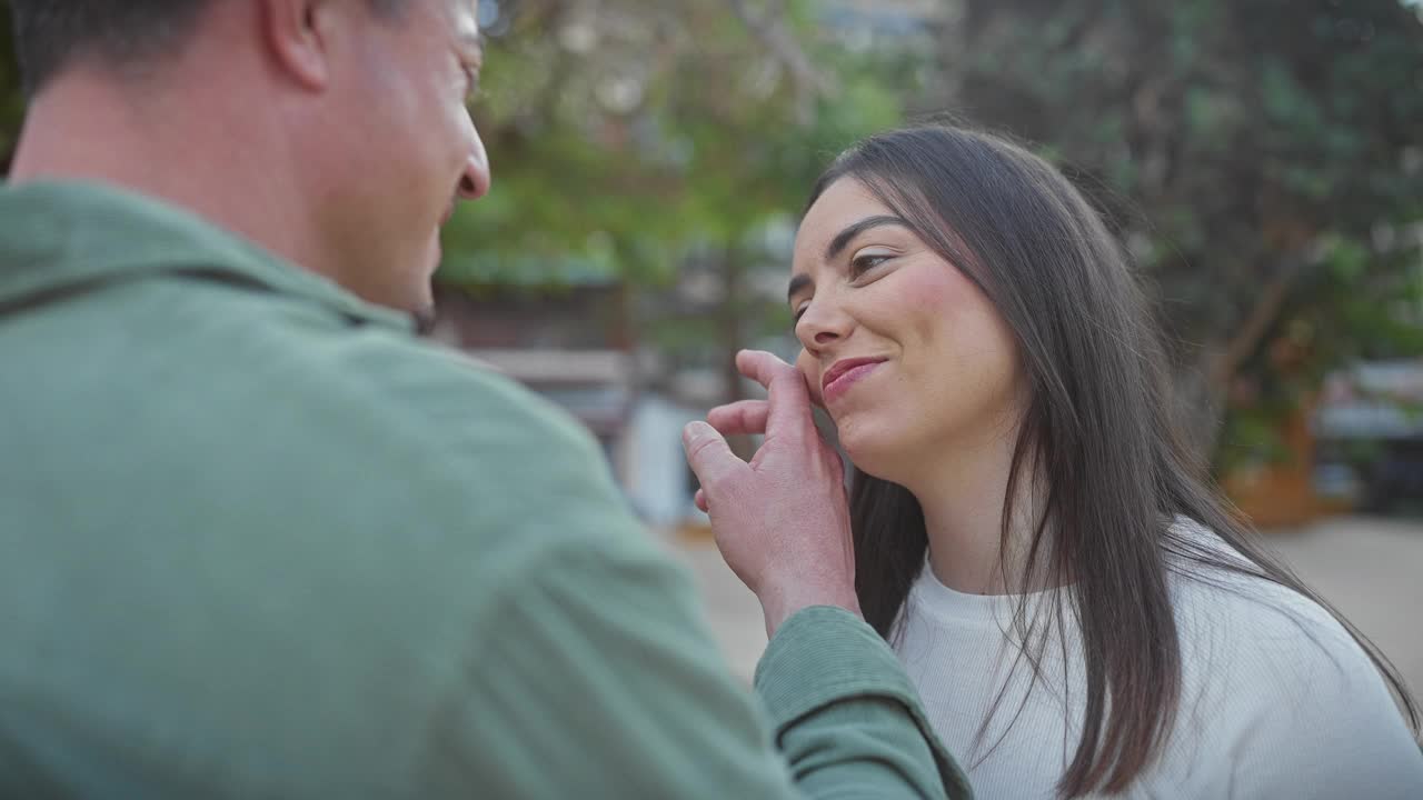 一个女人和一个男人在绿树环绕的户外深情拥抱视频素材