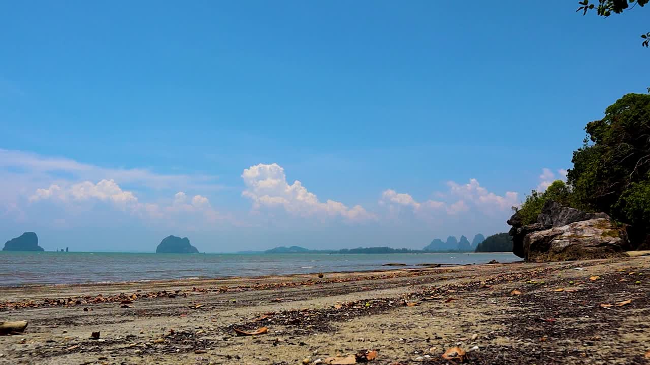 沙滩和大海在阳光明媚的一天，在泰国庄朝迈海滩视频素材