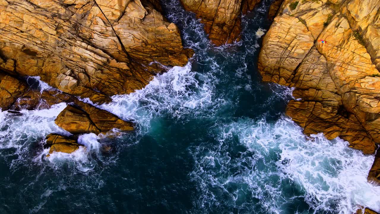 夏季，香港海滩上海浪撞击岩石的航拍慢动作视频素材