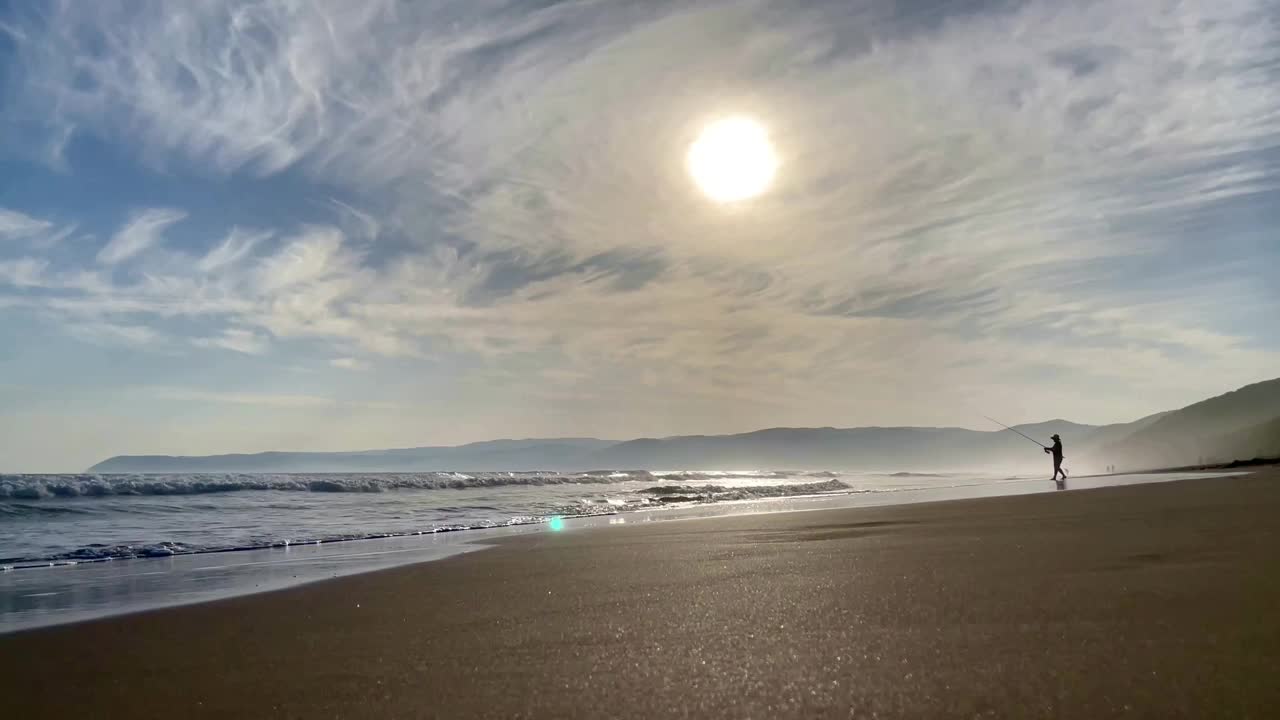 夕阳下渔夫垂钓鱼的剪影。爱好生活钓鱼运动概念日落。澳大利亚海滩，一名男子拿着鱼竿放松。户外活动视频下载