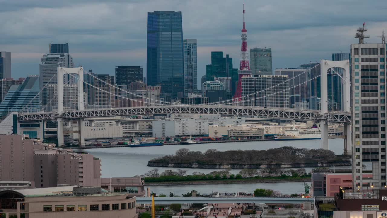 东京台场市的延时拍摄，彩虹桥、东京塔和摩天大楼代表着白天到晚上城市灯光和交通灯光的开启视频下载