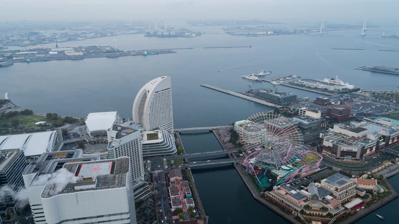 横滨地标性的港东未来地区的鸟瞰图代表了从白天到夜晚的过渡，城市的灯光和交通的灯光一起打开。4 k Res。视频下载