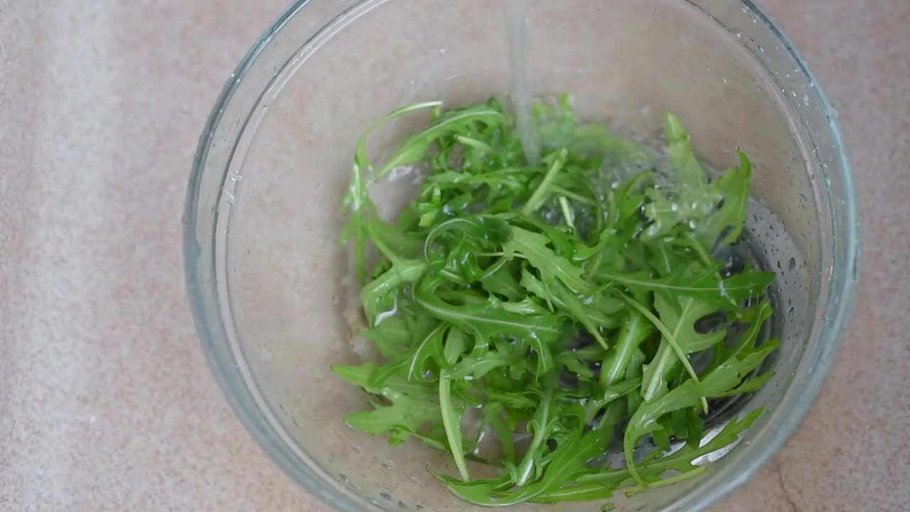 新鲜的芝麻菜叶子在水下清洗视频素材