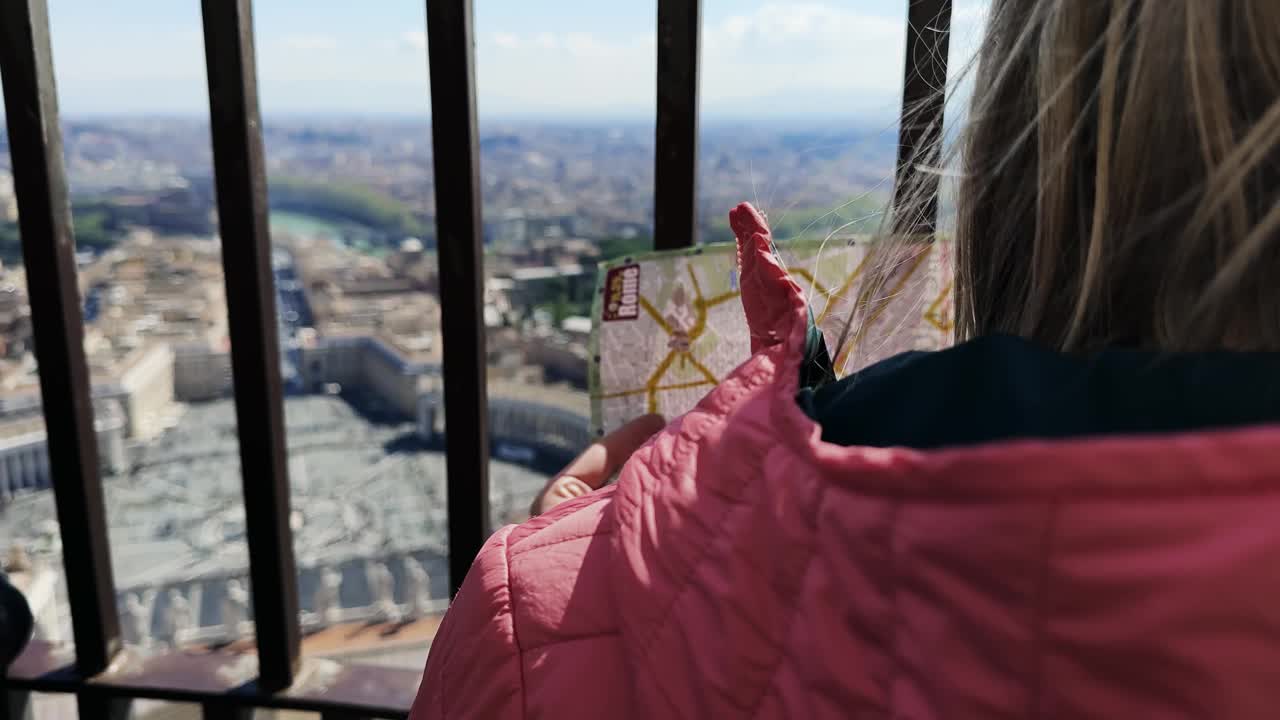 游客妇女在圣彼得教堂穹顶享受罗马全景寻找地图上的地标位置，慢动作电影镜头视频素材