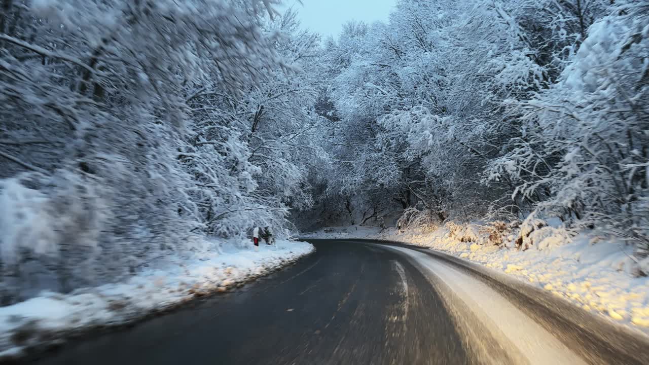 在冬季的高速公路上，汽车行驶在大雪和大风的湿滑道路上视频素材