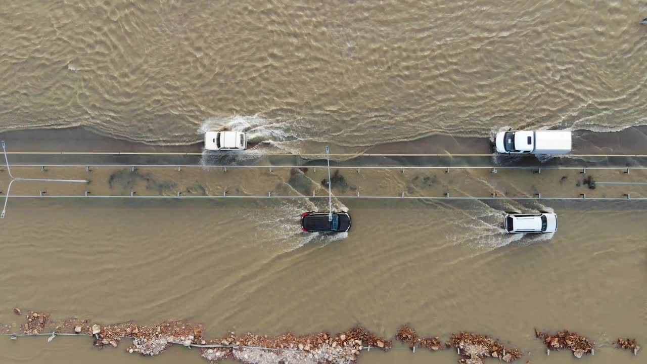 汽车和卡车行驶在被洪水淹没的高速公路上，在雨雪融化后的洪水中行驶视频下载