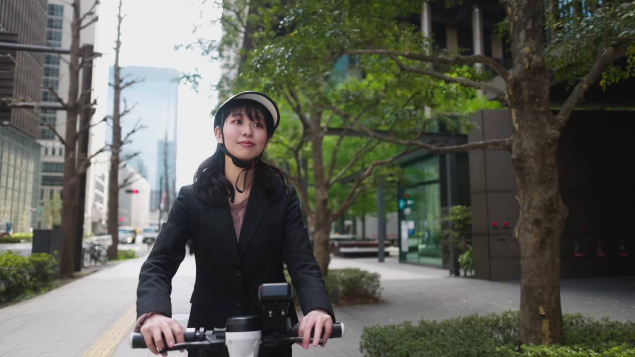 年轻的女商人骑电动滑板车在城市-二集之一视频素材