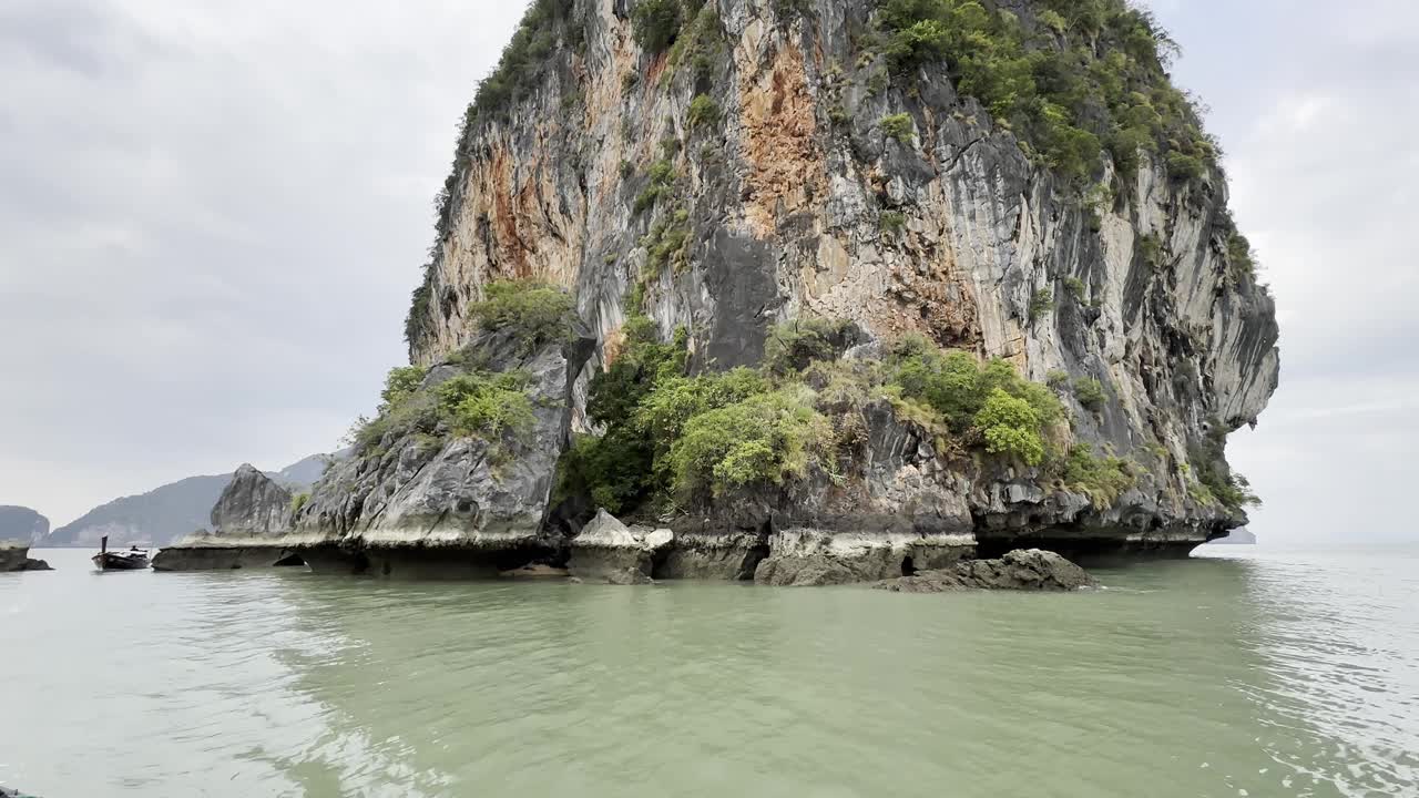 宁静的镜头展示了一个宁静的绿色山岛坐落在蔚蓝的海水中，提供了一个风景如画的逃避大自然的宁静视频素材