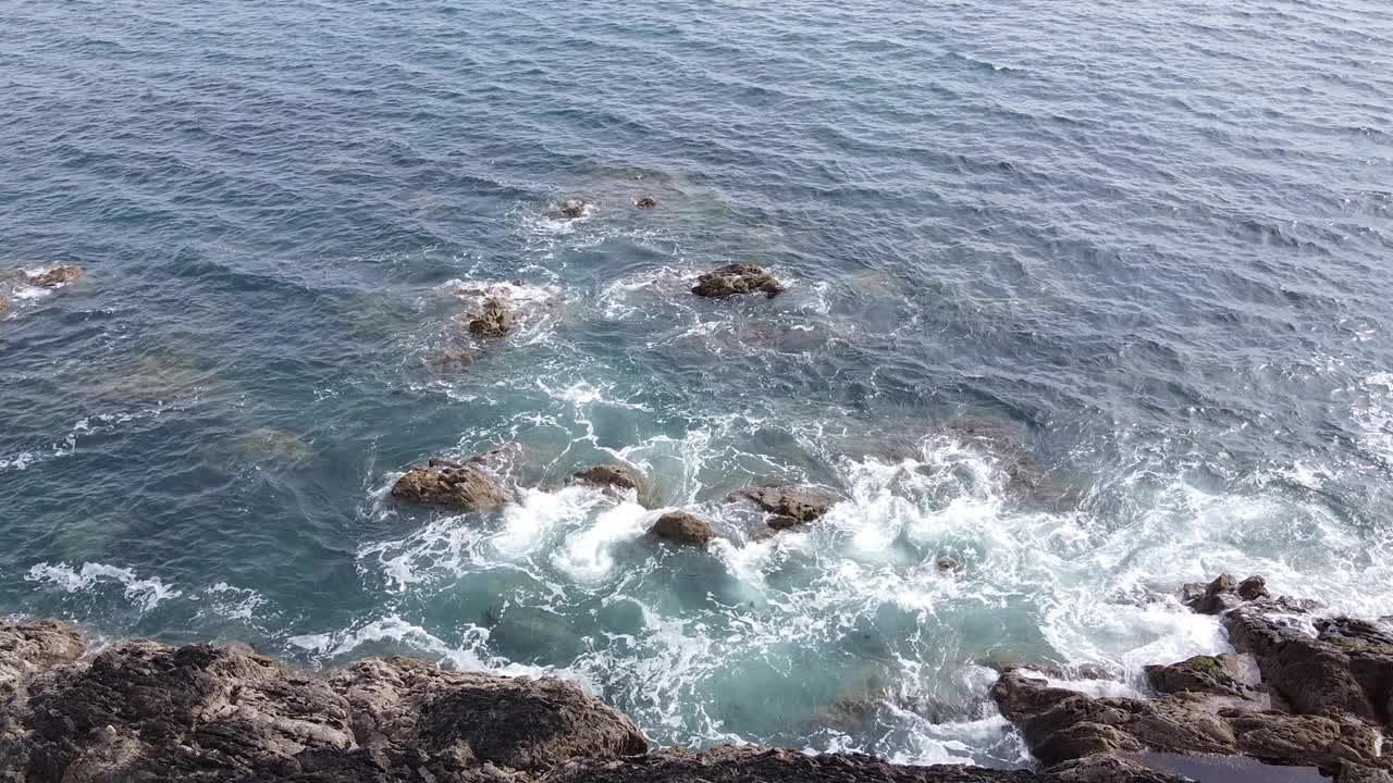 蓝蓝的海水飞溅在岩石海岸，俯视图。海边。视频素材