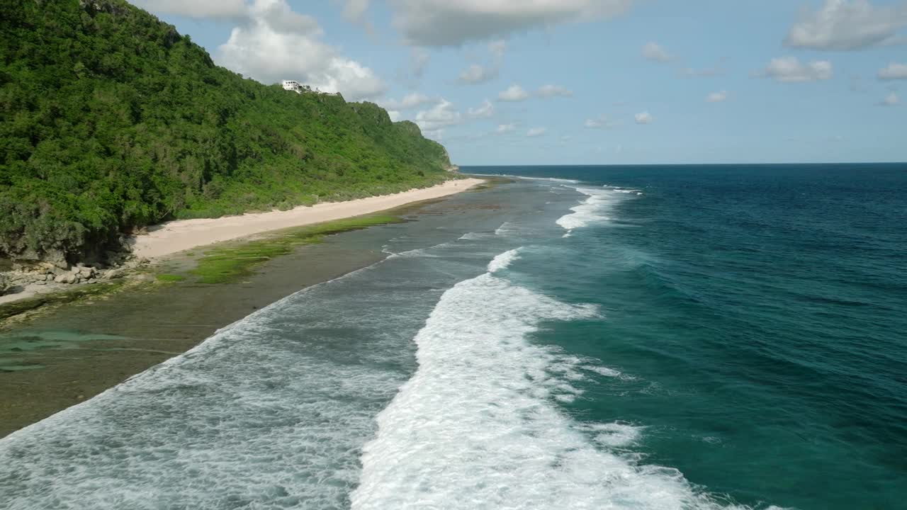 蓝色的海浪冲击着巴厘岛的沙滩和丛林视频素材