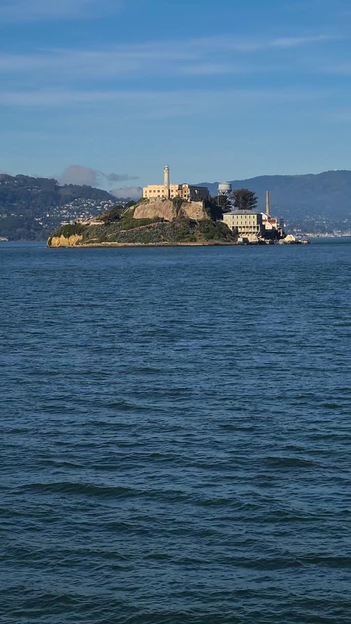 垂直视频，恶魔岛和前监狱建筑从渡轮航行在旧金山湾视频素材