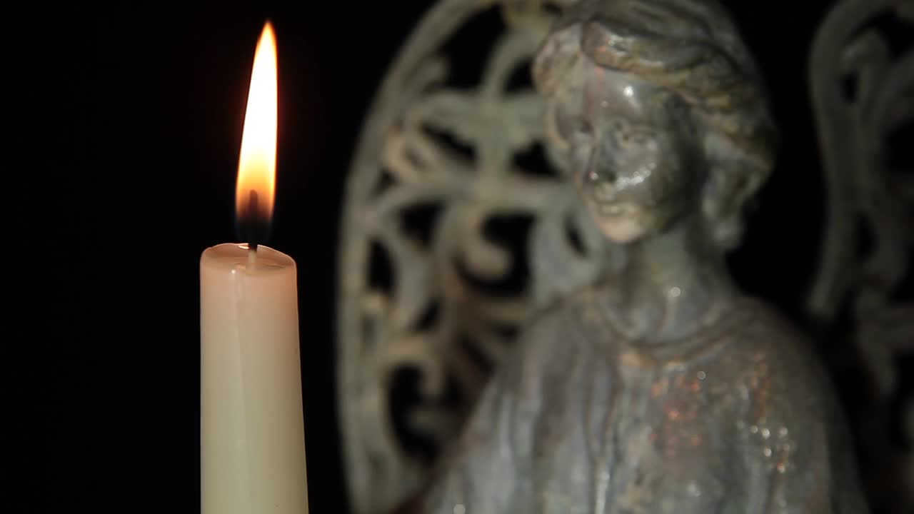 天使雕像蜡烛暗背景视频素材