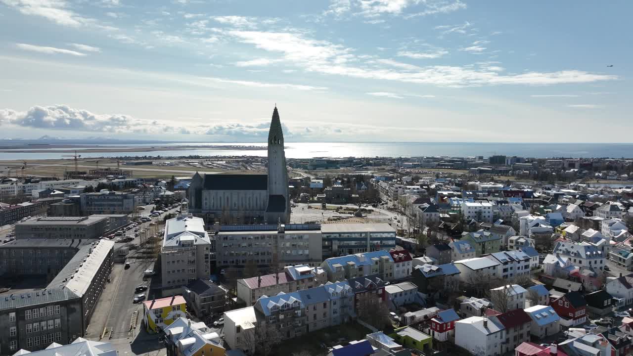 在一个阳光明媚的日子里，在美丽的Hallgrímskikirkja教堂塔楼和Reykjavík市中心后面盘旋。视频素材